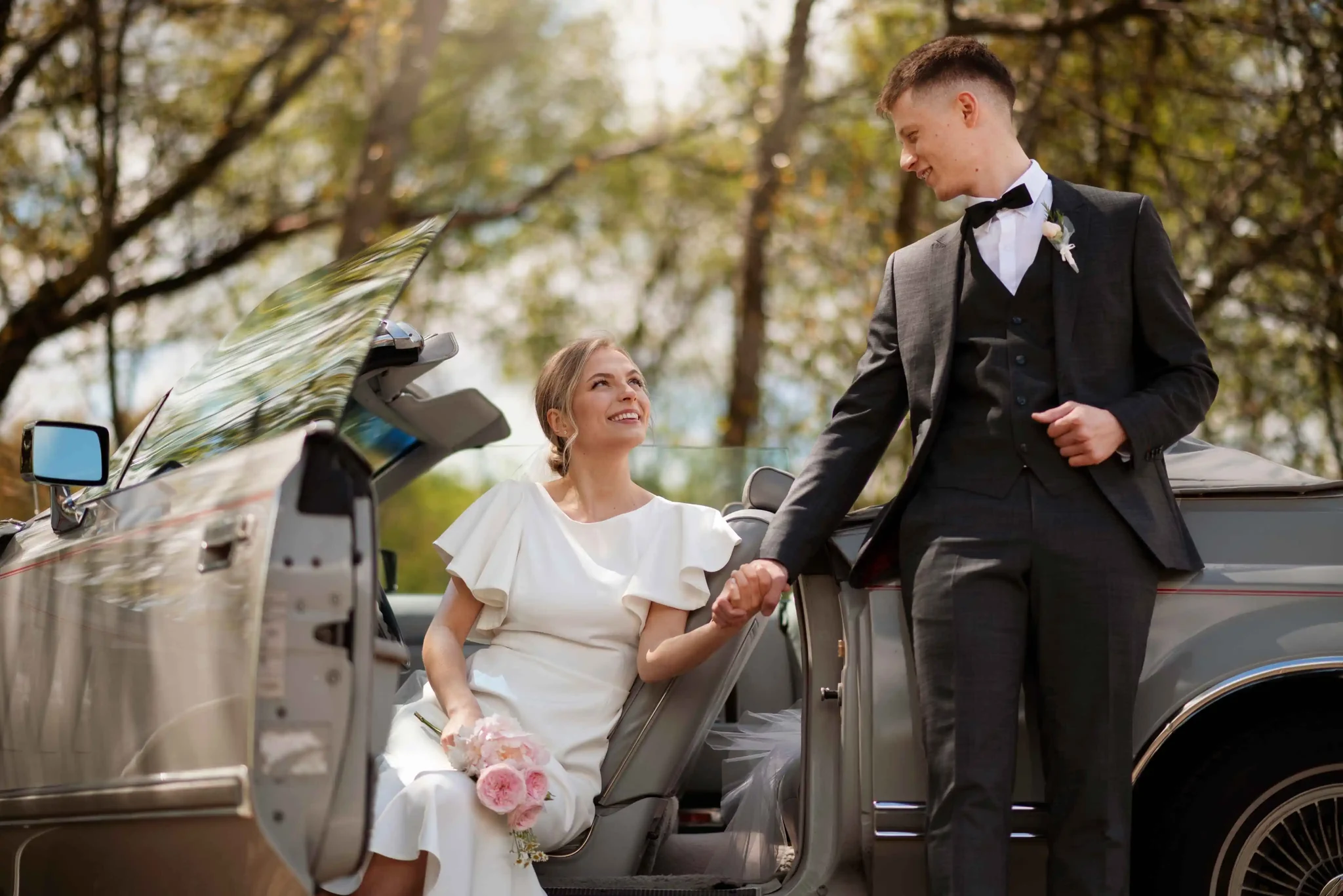 Bride and groom beside a Blackdoor Limo wedding car